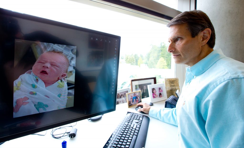 John Kahan looks at a photo of his son, Aaron, on a computer screen