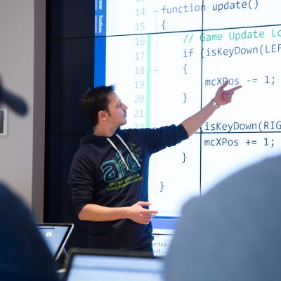 A man points at text on a large screen