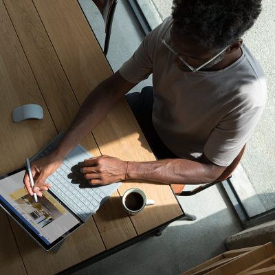 A man uses a Surface tablet at his kitchen table