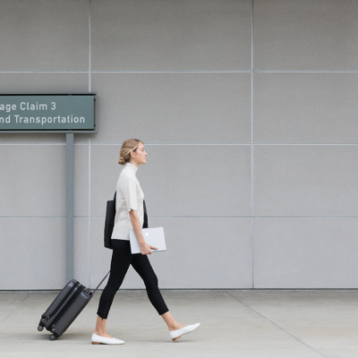 A woman holds a Surface tablet as she walks to baggage claim