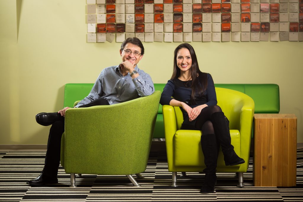 Jordi Ribas and Kristina Behr sit in green chairs, smiling at camera