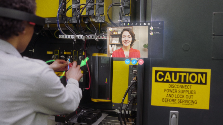 a woman working with her hands conferences with another woman via HoloLens technolgoy