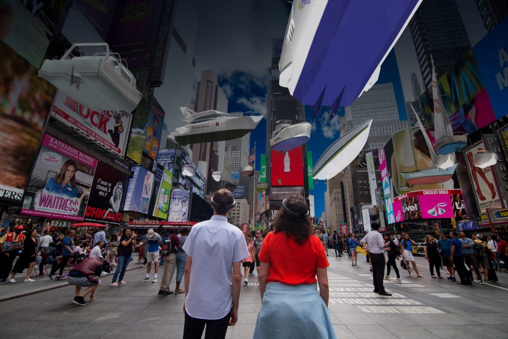 Two people wearing Microsoft HoloLens look up at Times Square to see a variety of floating boats.