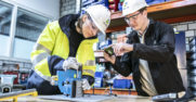 a man and a woman work on a piece of equipment