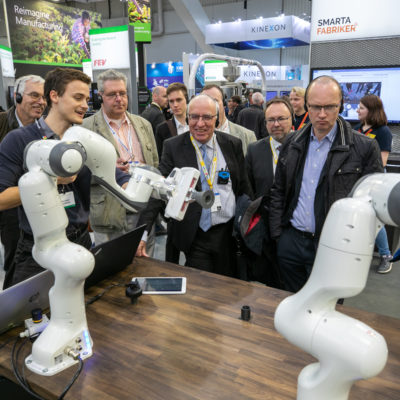 A booth tour group enjoys a robotics demo at Hannover Messe 2019