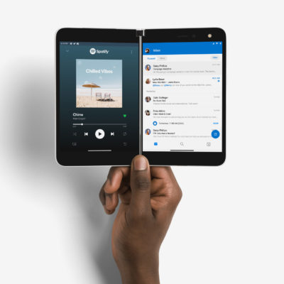 Hand holding Surface Duo displaying Spotify and Outlook