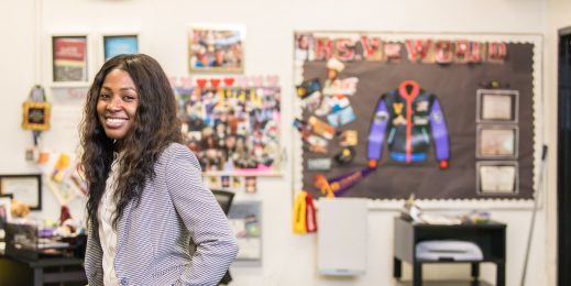 Female teacher stands in a classroom with a colorful background