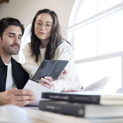 Man and woman viewing what's on a Surface Duo 2