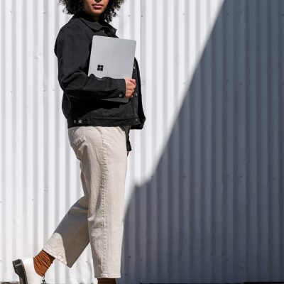 A woman holds a Surface laptop