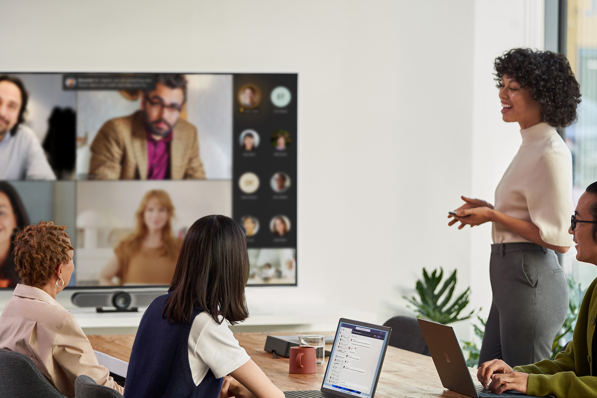 Four people in an office in a Microsoft Teams meeting with others