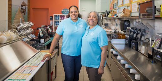 Two women stand in a kitchen smiling