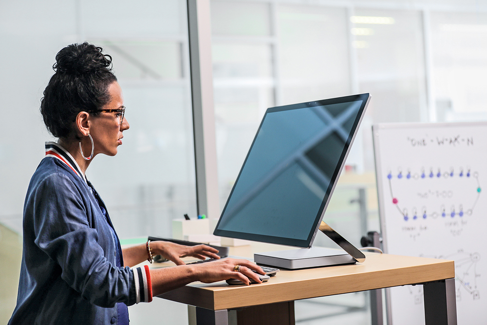 Young woman seated facing a large computer screen