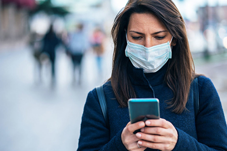 Woman weaing mask using cell phone