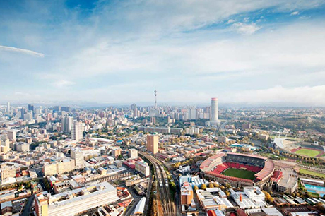 Birds eye view of multiple buildings accompanied with a blue sky and white clouds