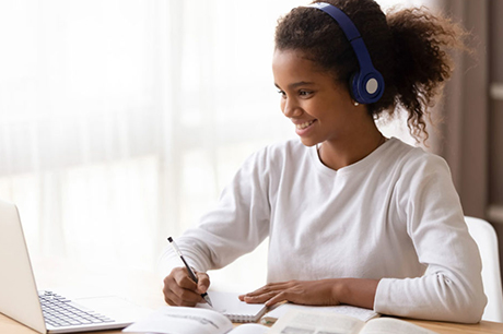 Teenage girl engaging in online coursework from home