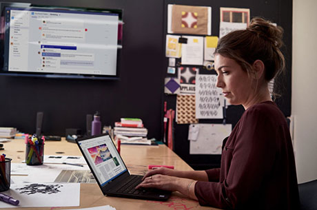 Woman working at her laptop in a boardroom