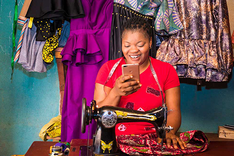 woman in red smiling at smart phone