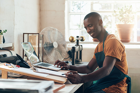 A young African man sitting in his workshop as he brainstorms new product ideas.