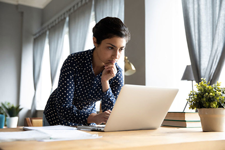 A business woman works on her laptop in the comfort of her own home.