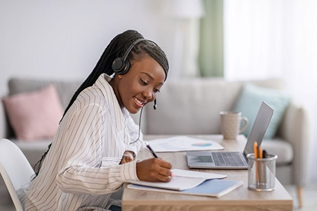 young woman smiling and wriing on paper