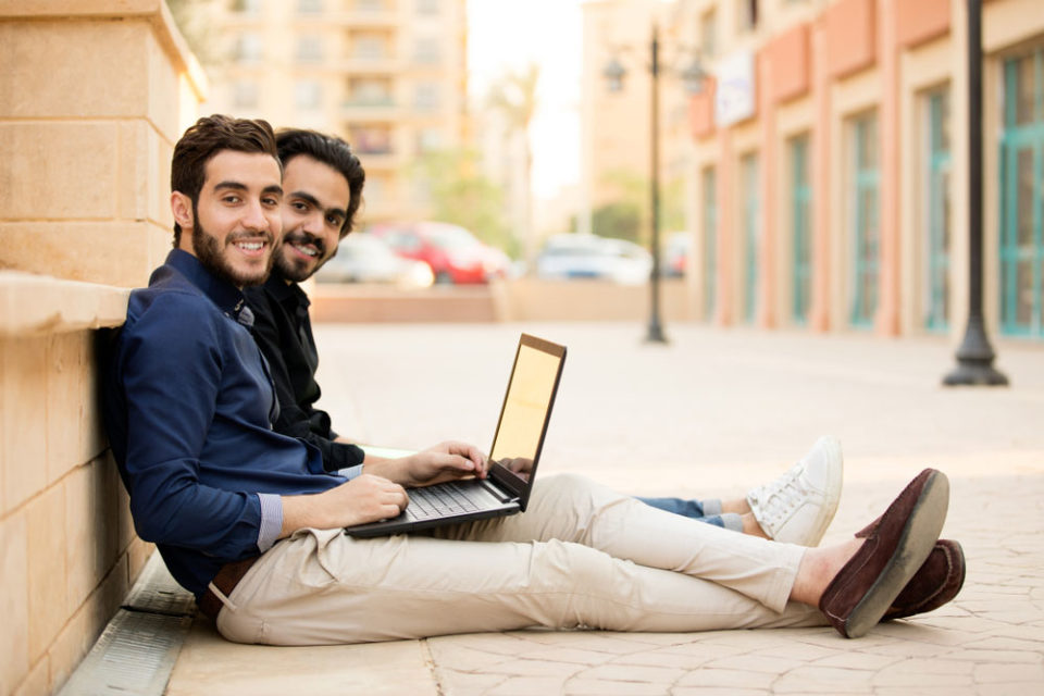 Two young male students present at a university campus.