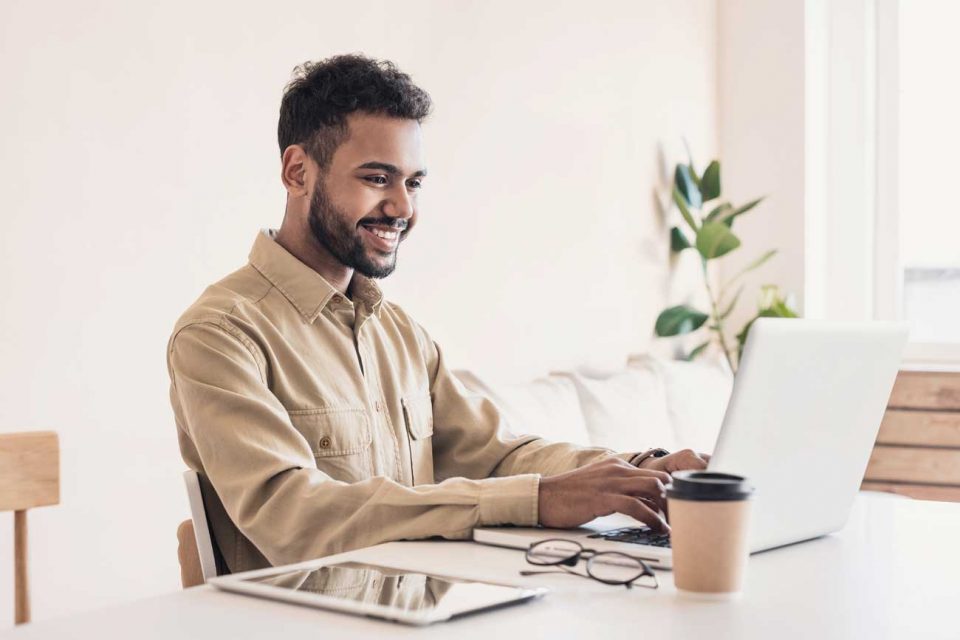 Young male professional working from home on a laptop.