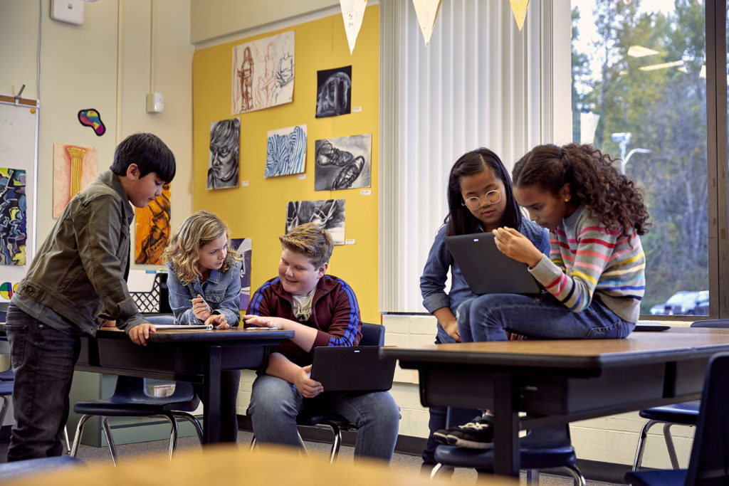 Students working on laptops and other devices