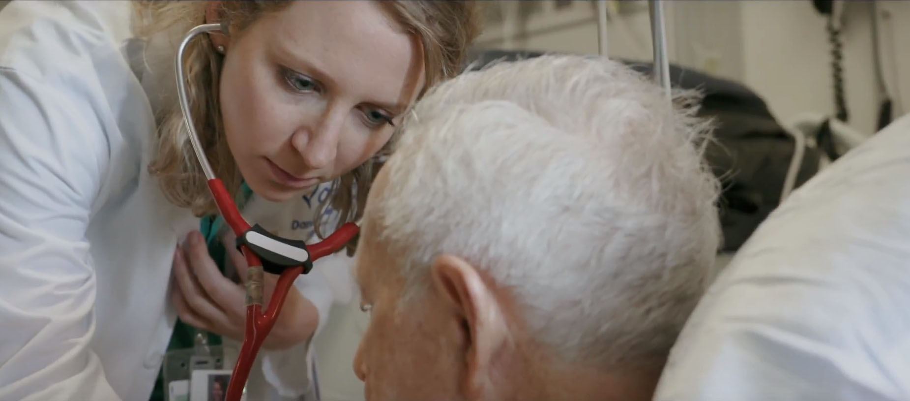 Doctor with stethoscope checks on a patient in a hospital