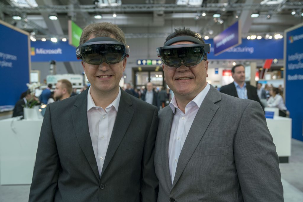 Ralf Krieger and Walter Bauch wear HoloLens at the Hannover Messe trade fair.