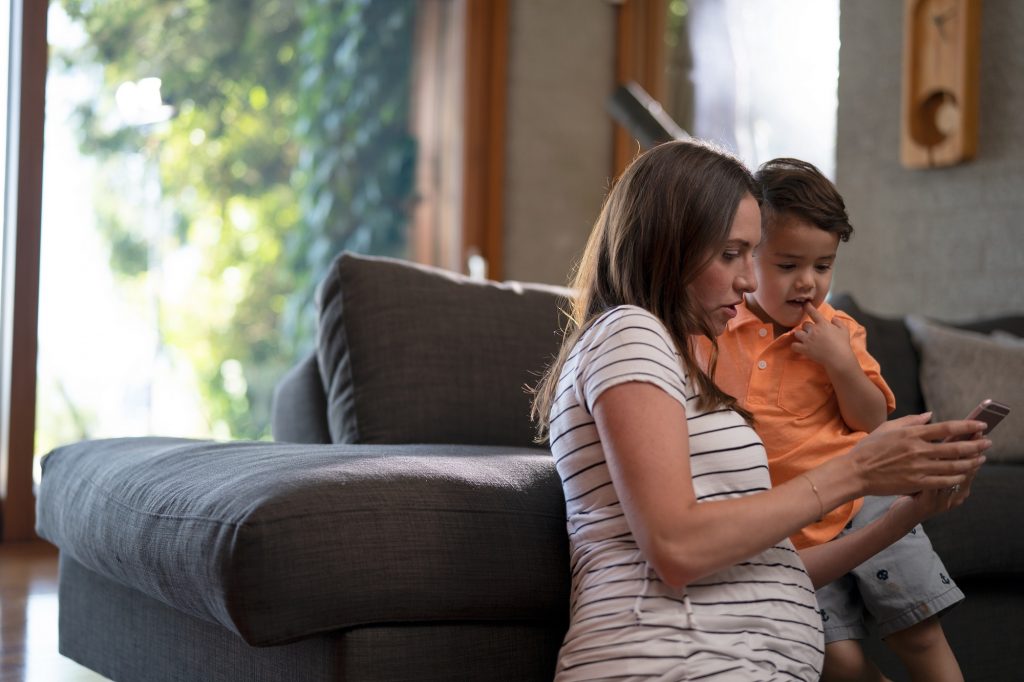 woman and child look at a mobile phone