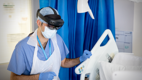 An NHS doctor at St. Mary’s Hospital speaks with a patient on a COVID-19 ward during the pandemic whilst wearing a Microsoft HoloLens 2