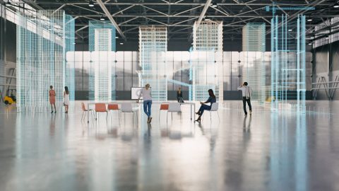 People stand and sit in a warehouse.