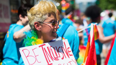 Parade-goer holding a sign