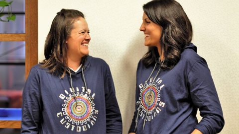 Two women grinning at each other