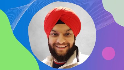 Davinder is smiling, wearing a red Dastar or Turban