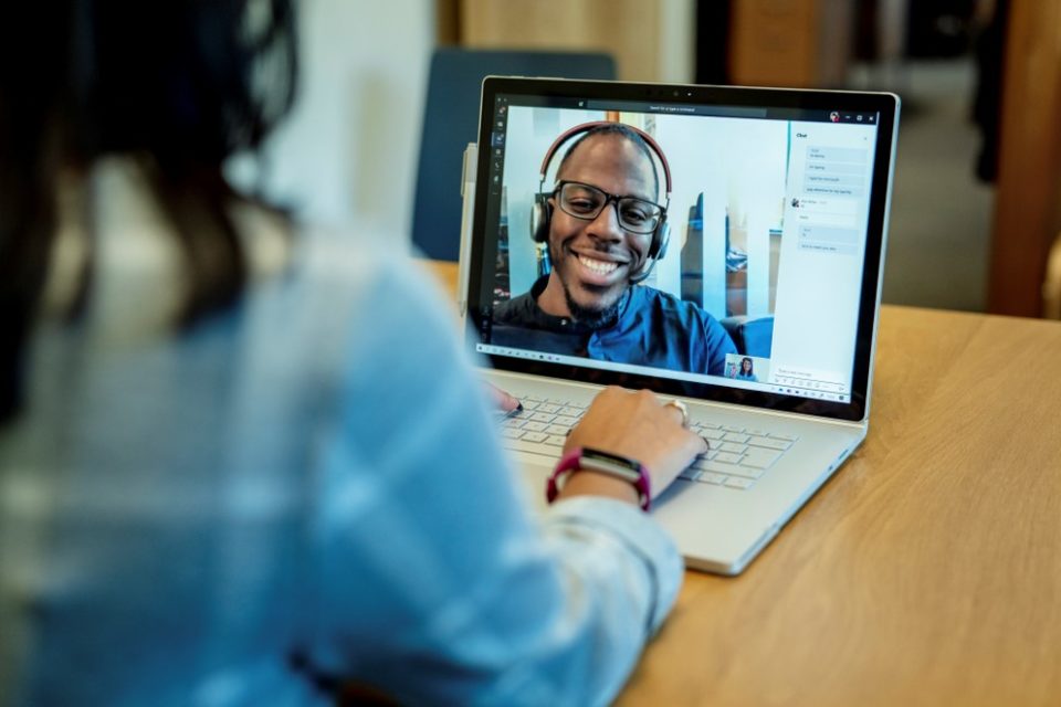 Blick über die Schulter einer Schülerin, die ein Surface Book verwendet um mit ihrem Lehrer via Teams zu videotelefonieren