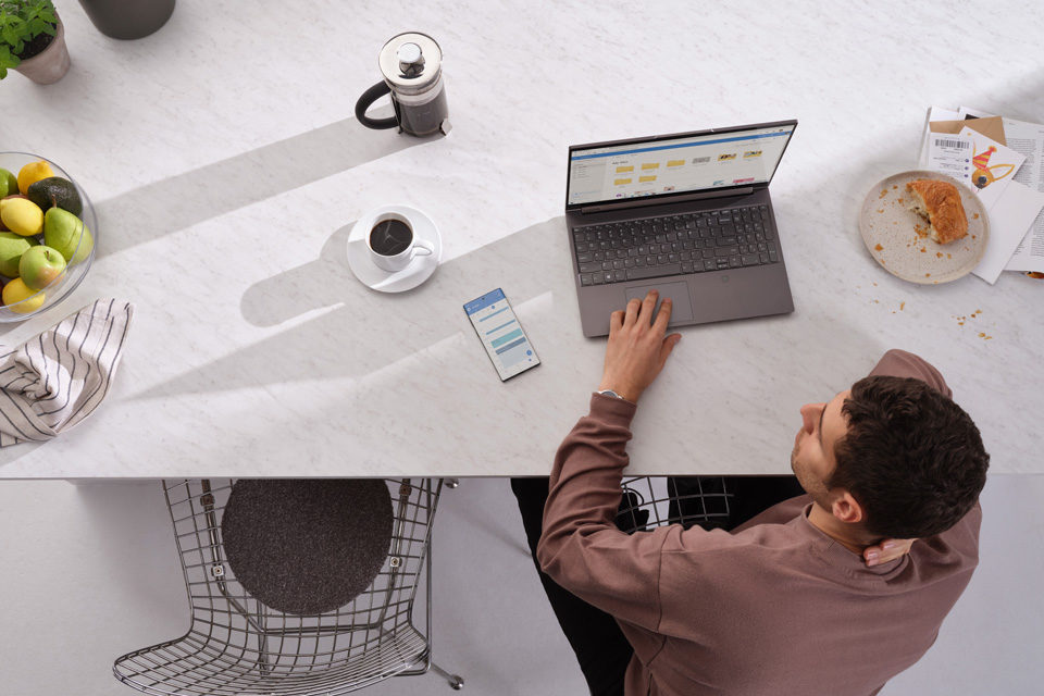 Mann sitzt vor Laptop und stöbert im OneDrive Ordner