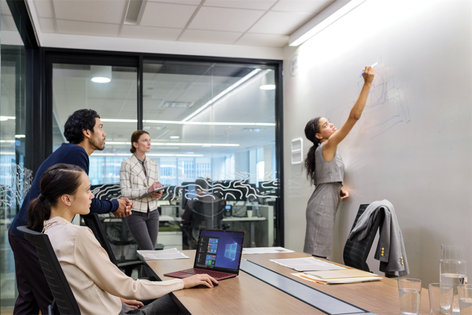 Meetingraum, eine Frau schreibt an ein Whiteboard