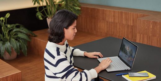 Frau sitzt vor Laptop an einem Schreibtisch