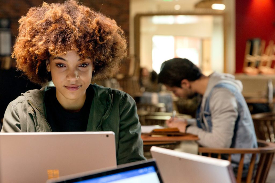 Junge Frau Mit Afro arbeitet an Surface-Gerät