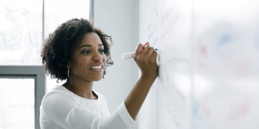 Frau schreibt an ein Whiteboard