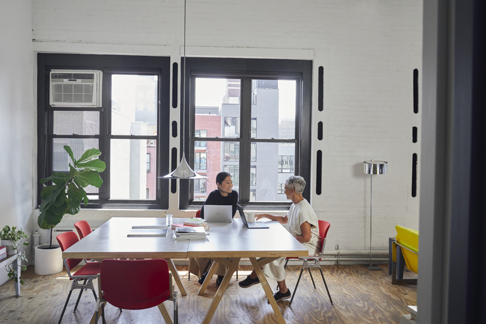 Zwei Menschen besprechen sich in einem modernen Büro