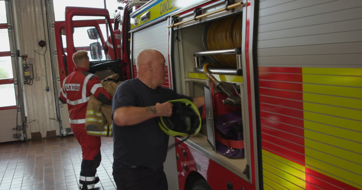 Dos hombres junto a un camión de bomberos