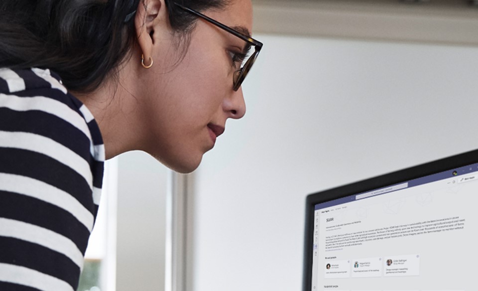 Una mujer con lentes frente a una laptop