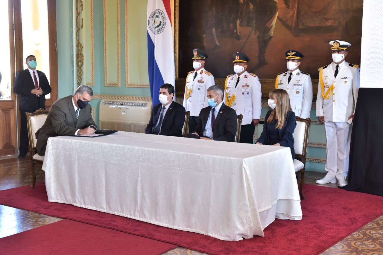 Personas con cubrebocas sentadas frente a una mesa