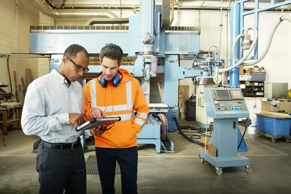 Ingenieros de manufactura interactúan con una tableta en las manos.