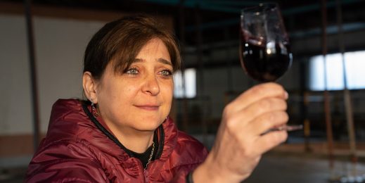 Una mujer mira una copa de vino en su mano