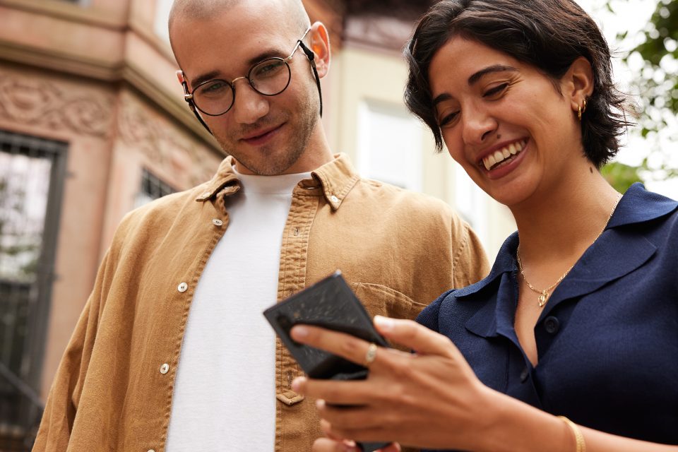 Un hombre y una mujer miran la pantalla de un teléfono móvil