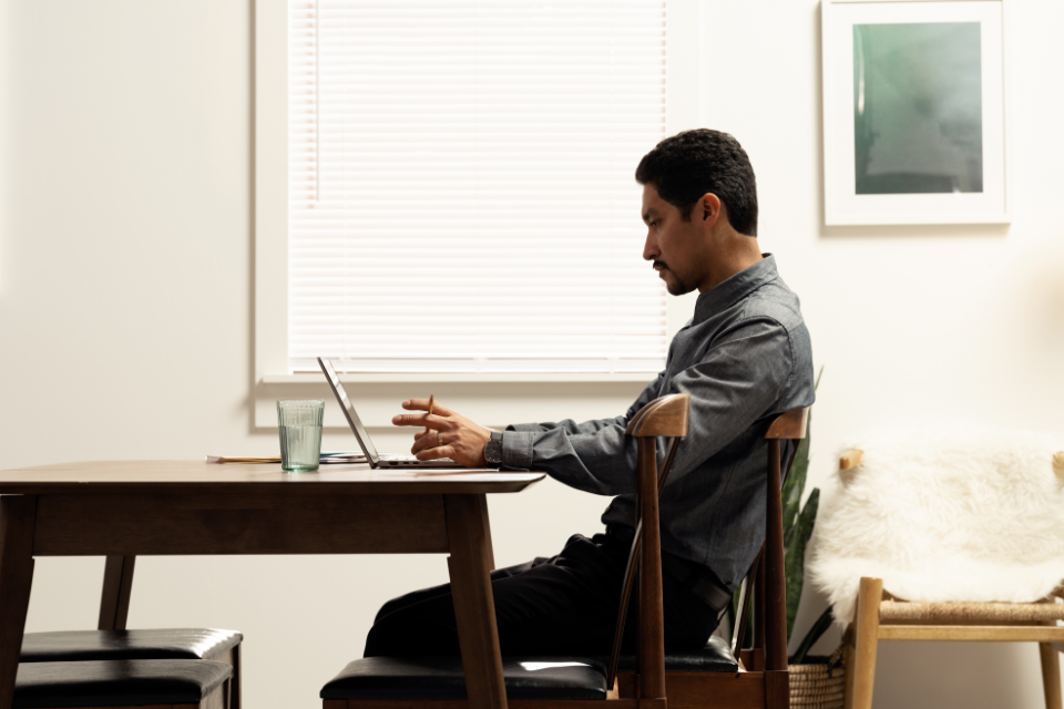 homem sentado em mesa com note aberto
