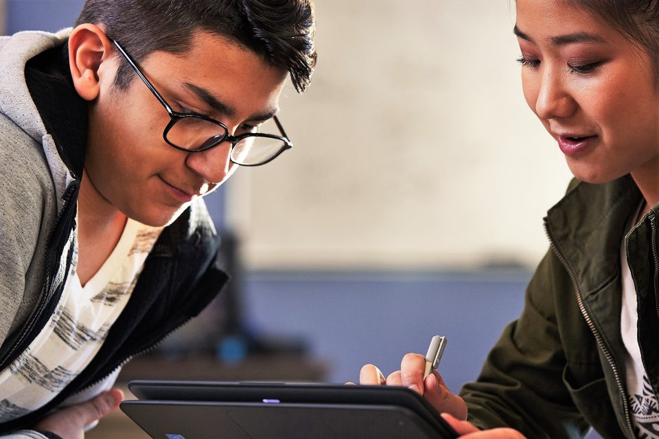 Two students looking at a device